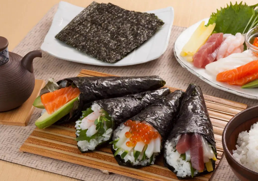 Temakis japoneses com salmão, ovas e vegetais, mostrando o significado do sushi enrolado à mão