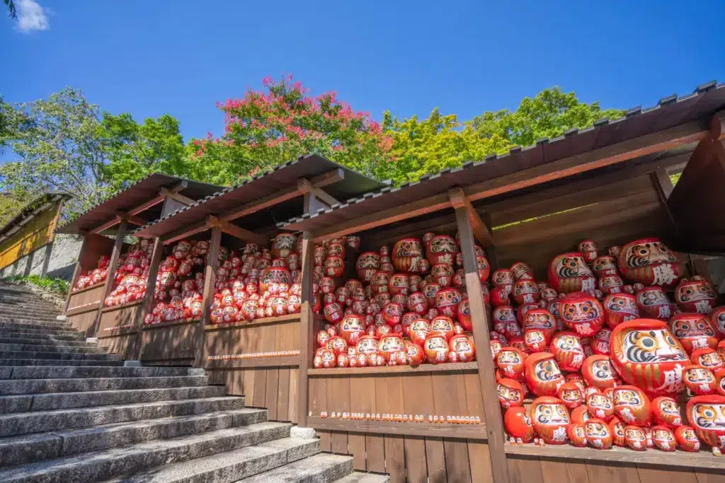 Daruma vermelhos expostos no Templo Katsuōji em Osaka, local tradicional para pedir sorte e conquistas no Japão
