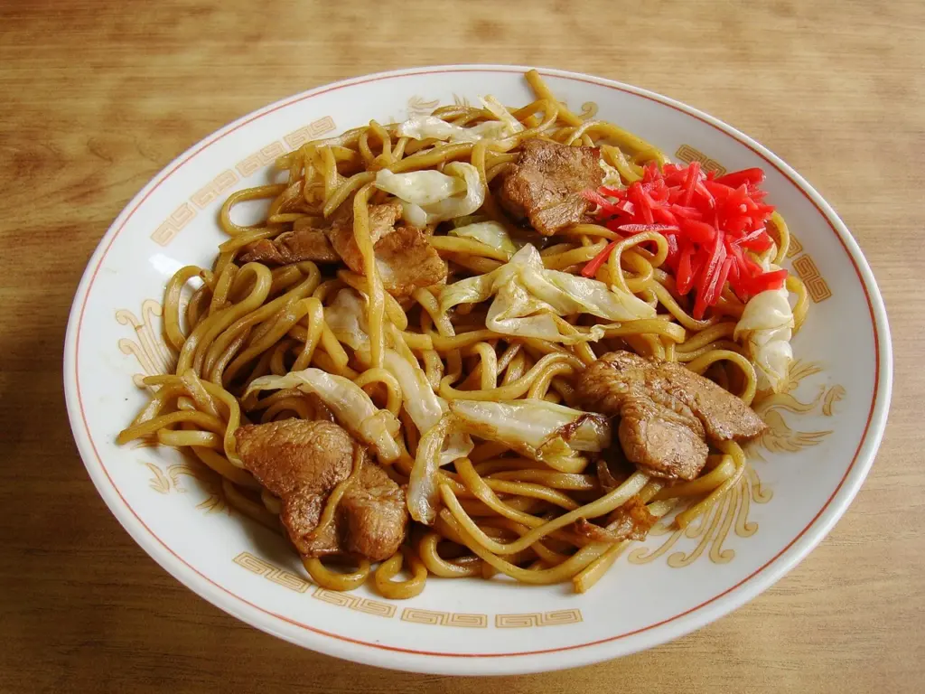 Prato de yakisoba japonês com carne, repolho e gengibre, representando o significado do nome macarrão frito